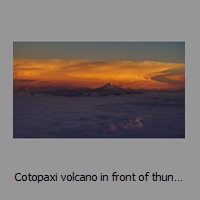 Cotopaxi volcano in front of thunderstorm cloud at sunset